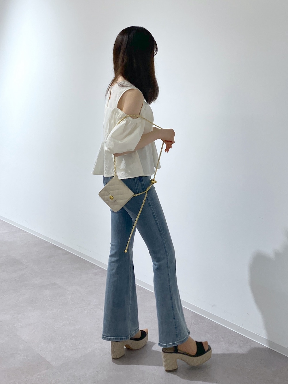 ホワイト系のシャツ/ブラウス、ブルー系のデニムパンツ、ブラック系のサンダルを着用したレディースの春コーディネートの5枚目の写真