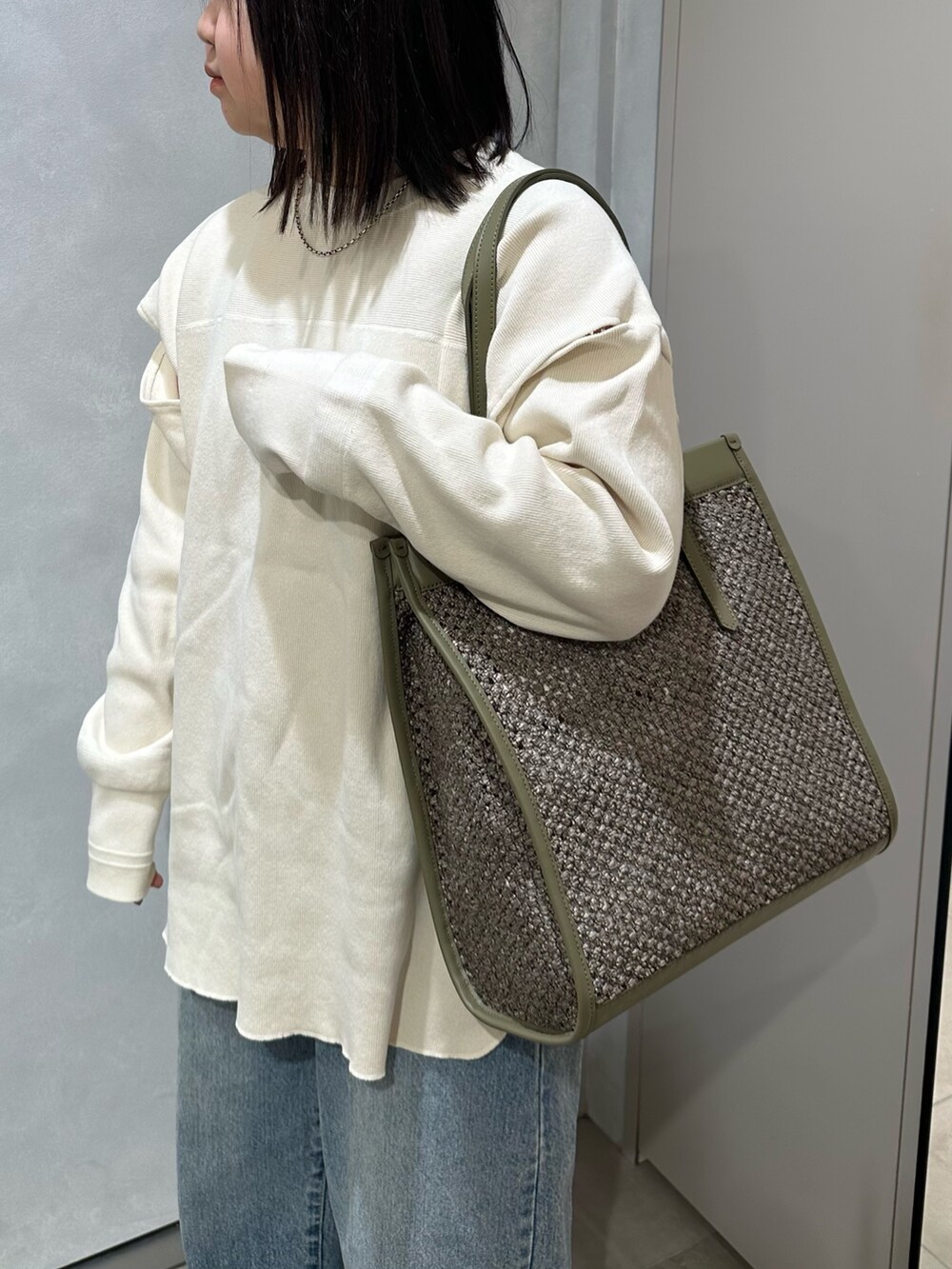 グリーン系のトートバッグを着用したレディースの春コーディネートの2枚目の写真