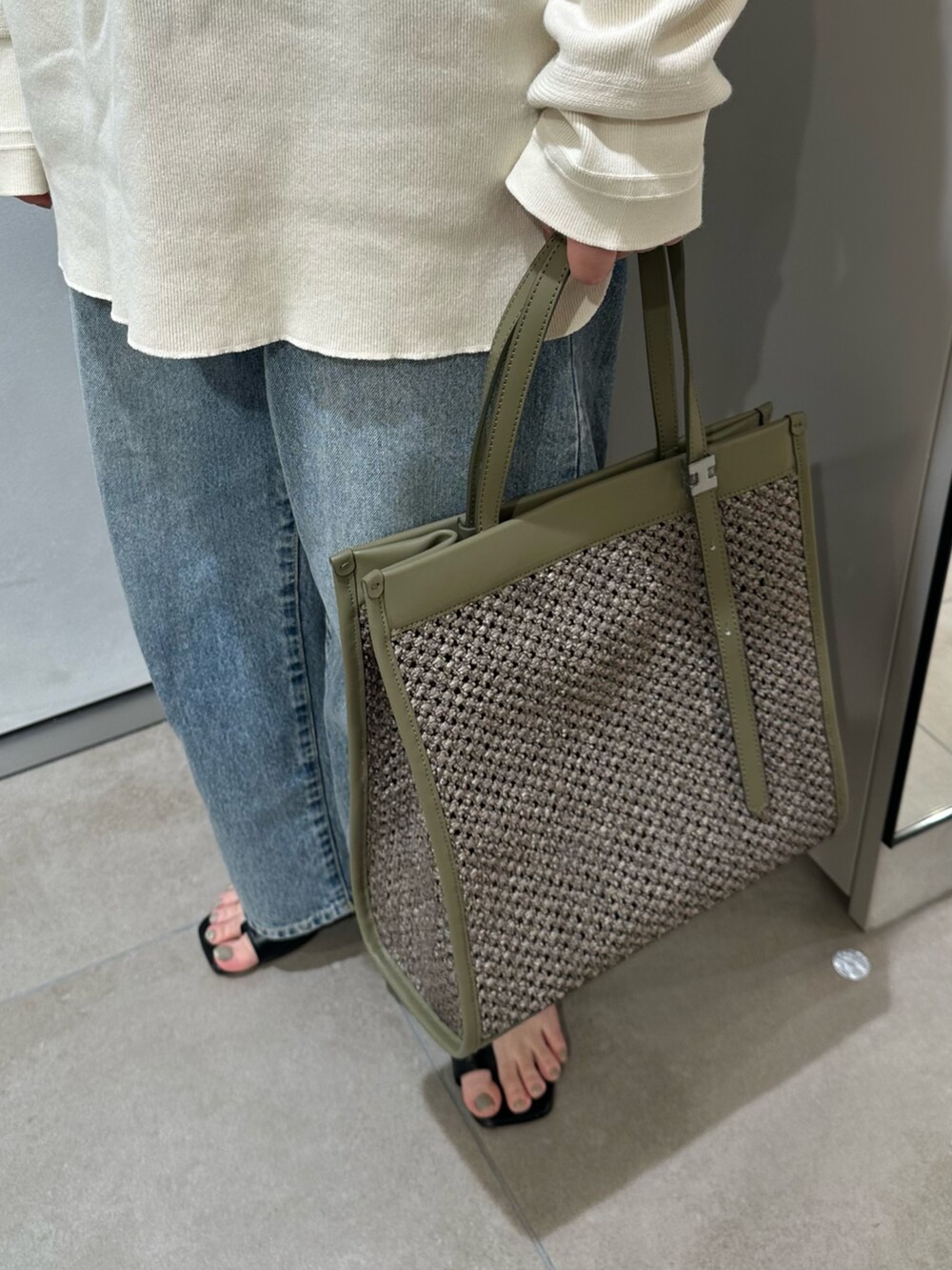 グリーン系のトートバッグを着用したレディースの春コーディネートの4枚目の写真