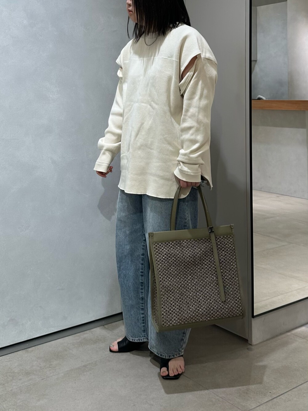 グリーン系のトートバッグを着用したレディースの春コーディネートの3枚目の写真