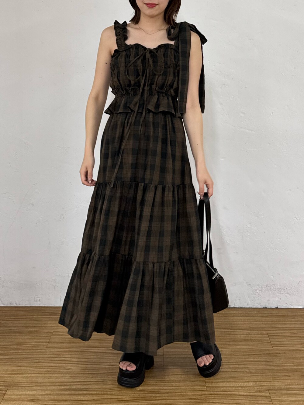 ブラウン系のワンピース、ブラック系のボストンバッグ、ブラック系のサンダルを着用したレディースの夏コーディネートの6枚目の写真