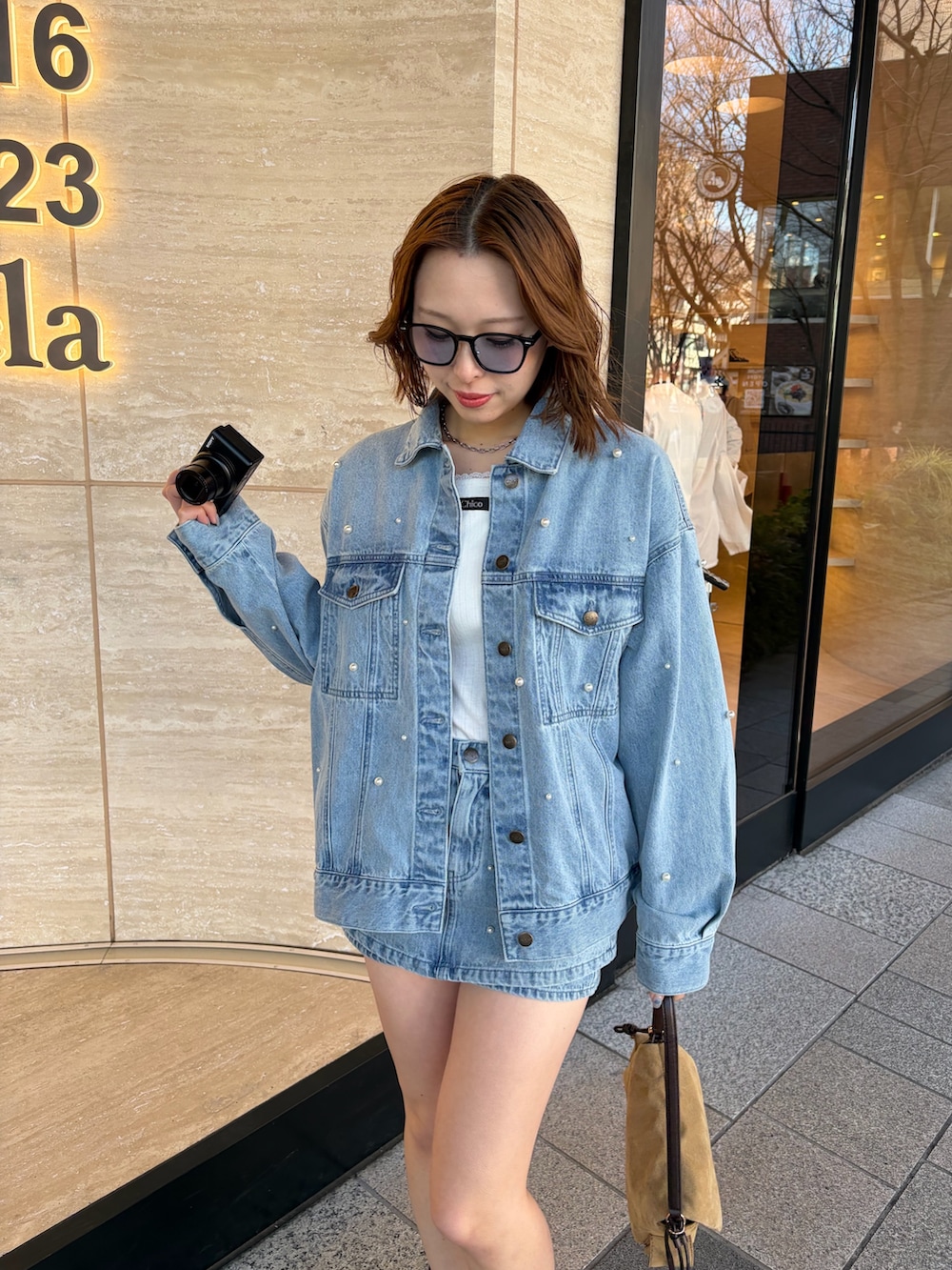 ブルー系のデニムジャケット、ホワイト系のTシャツ/カットソー、ブルー系のスカートを着用したレディースの冬コーディネートの2枚目の写真