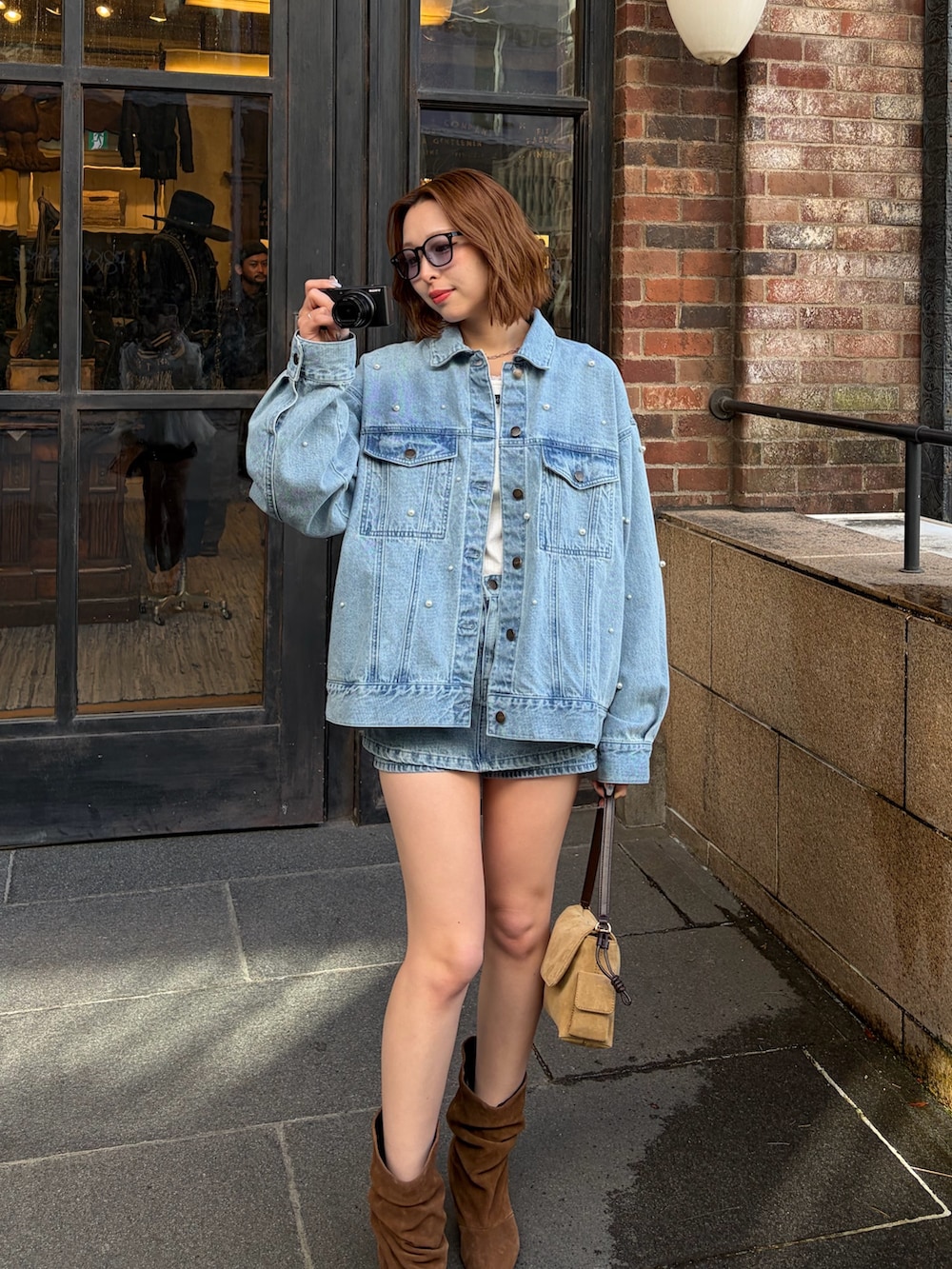 ブルー系のデニムジャケット、ホワイト系のTシャツ/カットソー、ブルー系のスカートを着用したレディースの冬コーディネートの3枚目の写真