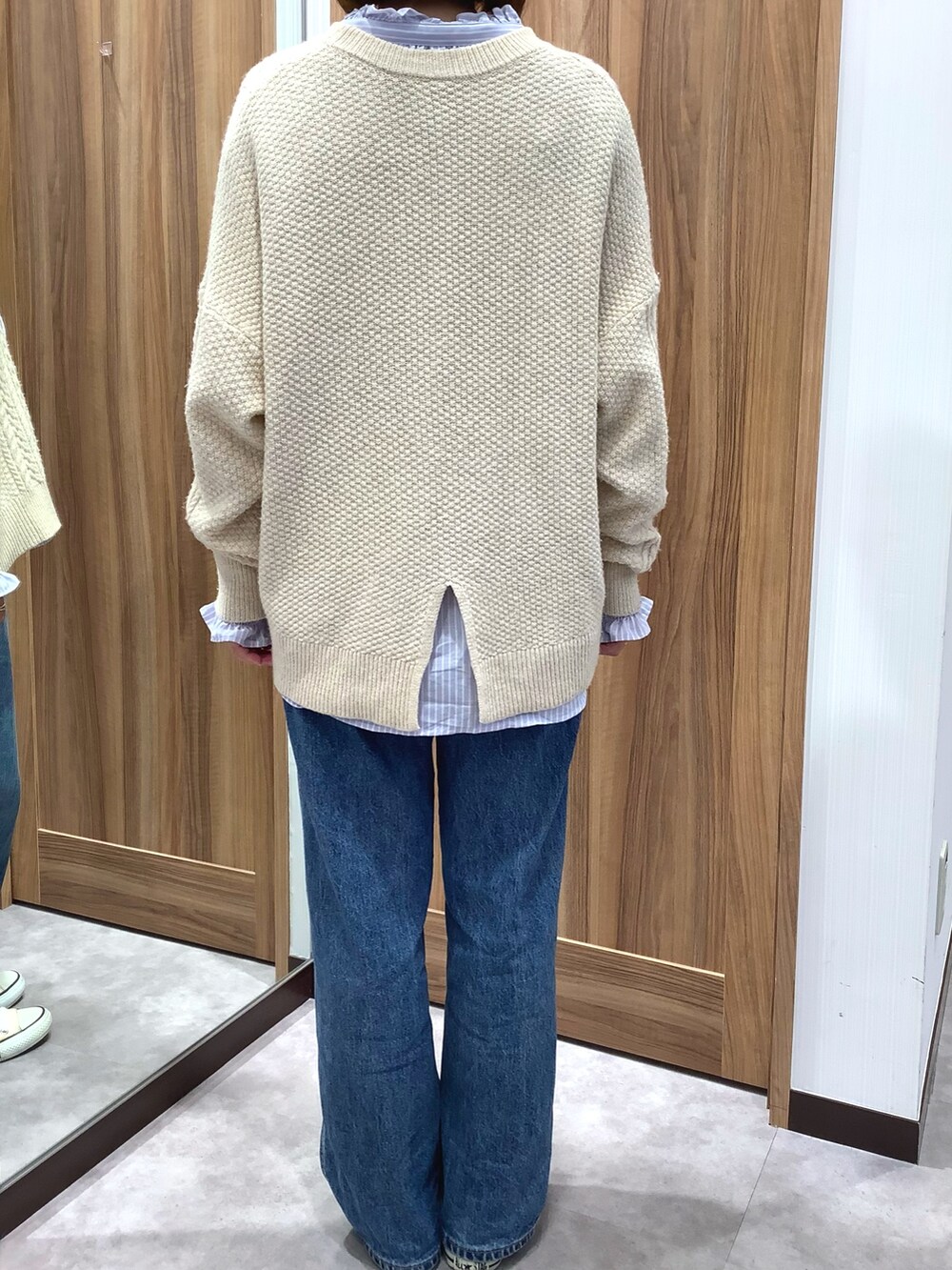 ブルー系のシャツ/ブラウス、ベージュ系のニット/セーター、ホワイト系のスニーカーを着用したレディースの冬コーディネートの2枚目の写真