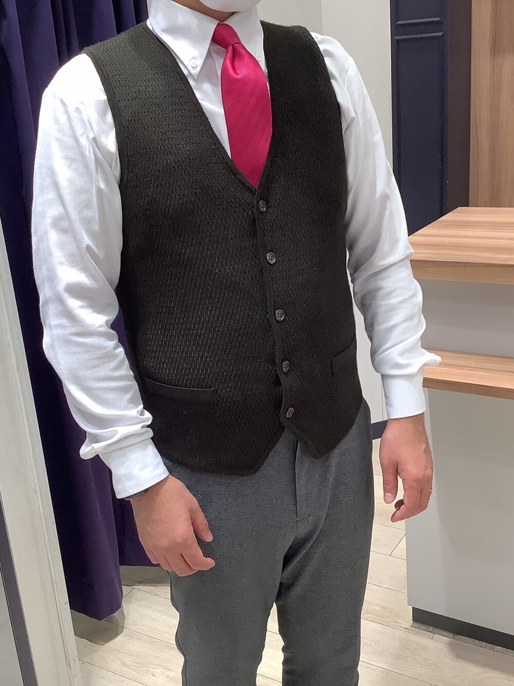 ブラウン系のベスト、ホワイト系のビジネスシャツを着用したメンズの秋コーディネートの2枚目の写真