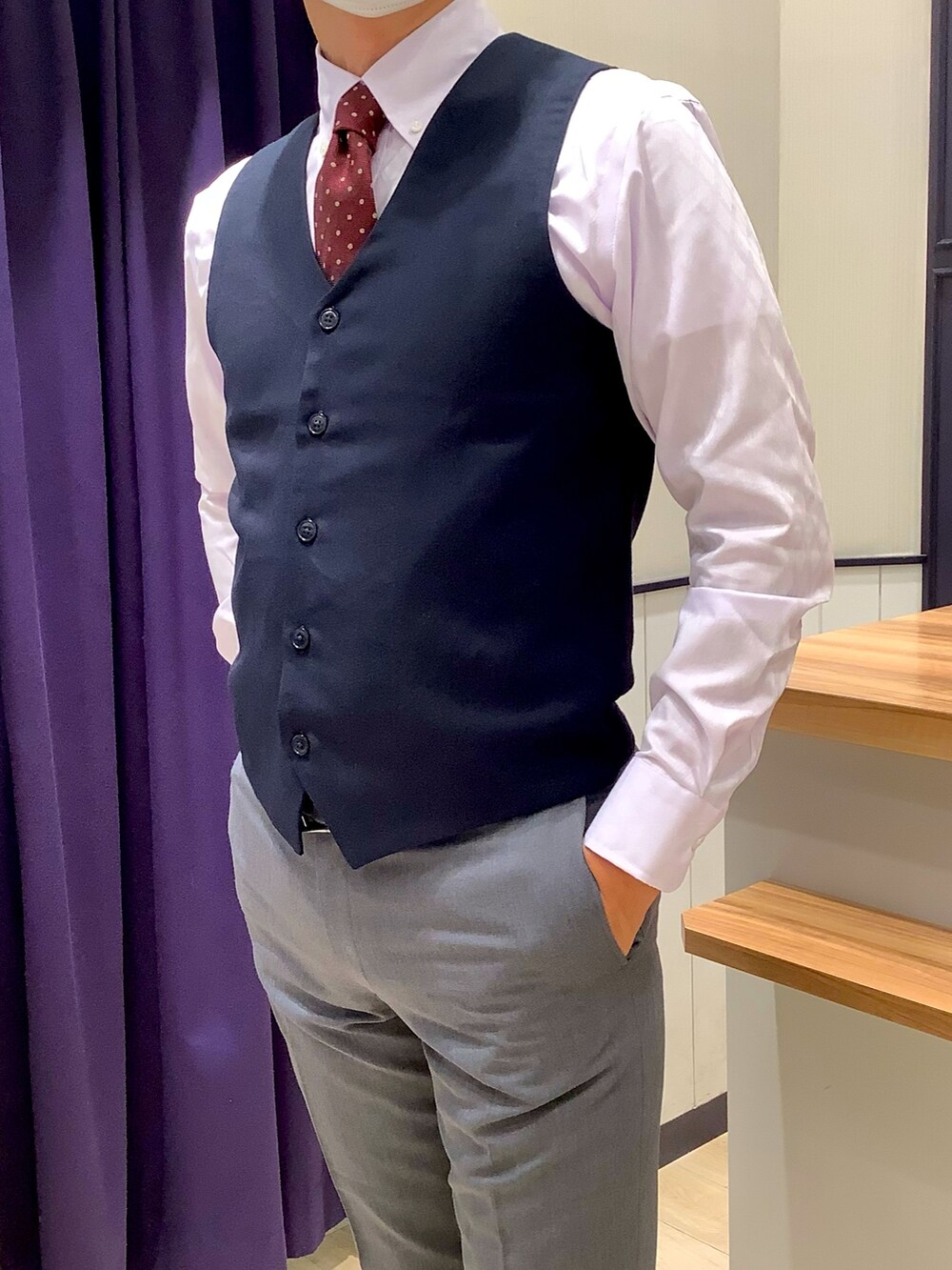 パープル系のビジネスシャツ、ブルー系のベスト、その他のネクタイを着用したメンズの秋コーディネートの2枚目の写真