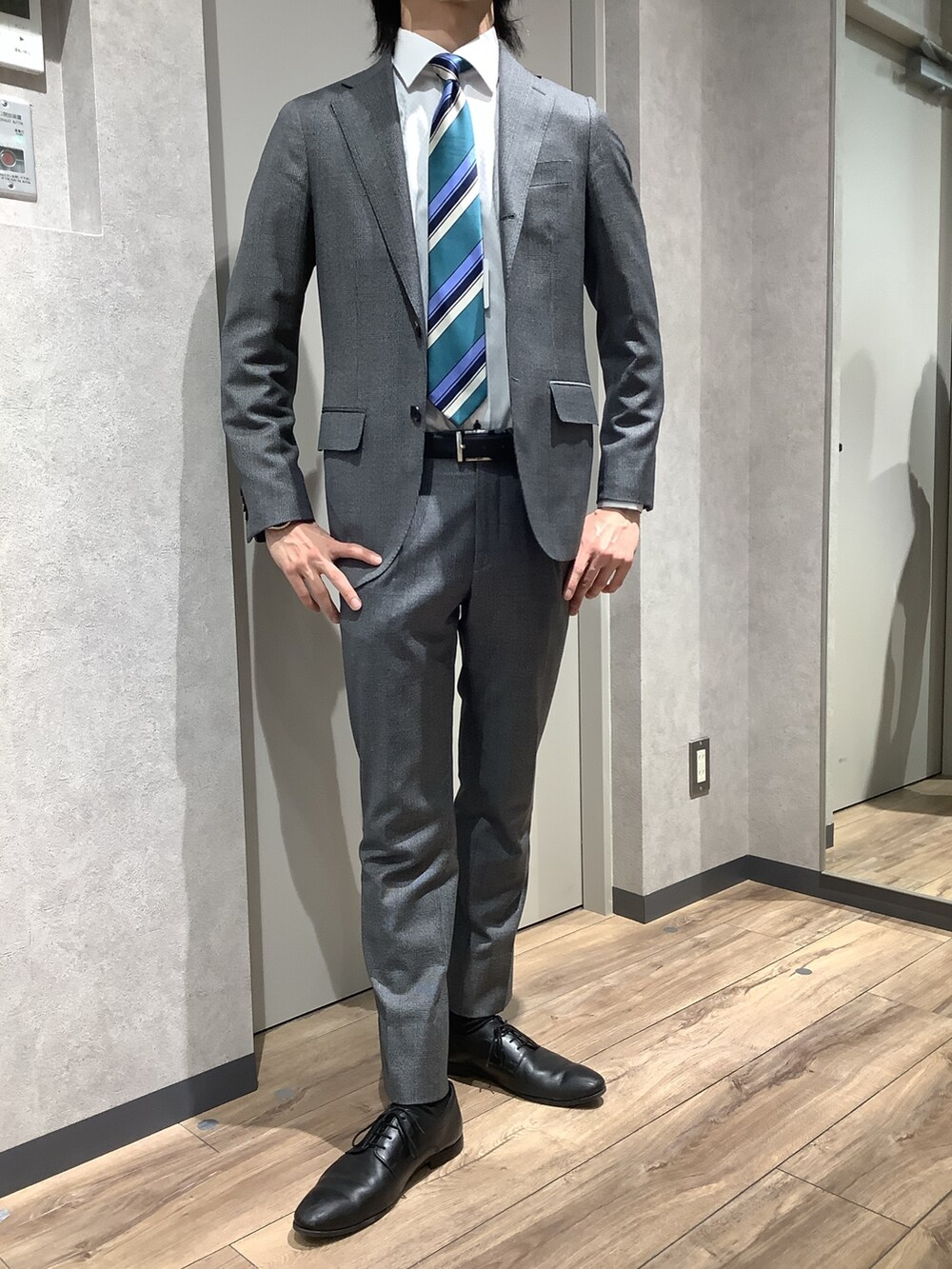 グリーン系のネクタイ、ホワイト系のビジネスシャツを着用したメンズの冬コーディネートの3枚目の写真