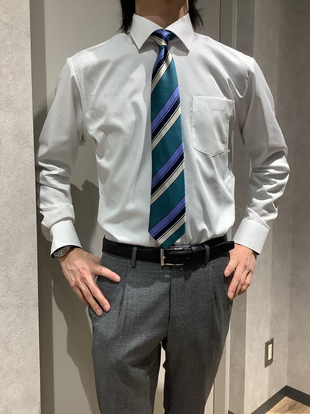 グリーン系のネクタイ、ホワイト系のビジネスシャツを着用したメンズの冬コーディネートの2枚目の写真