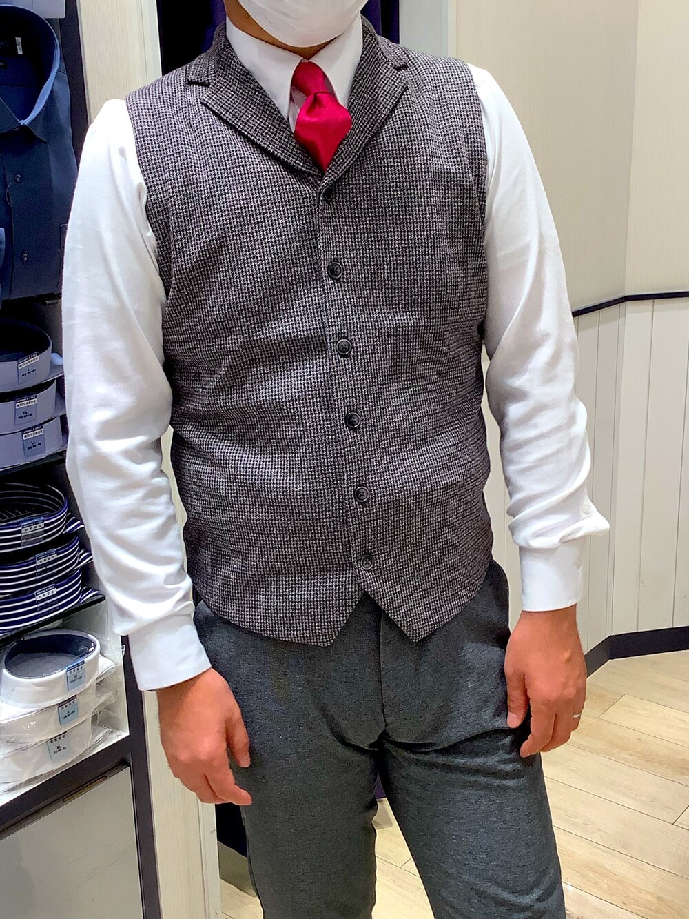 グレー系のベスト、ホワイト系のビジネスシャツを着用したメンズの秋コーディネートの2枚目の写真