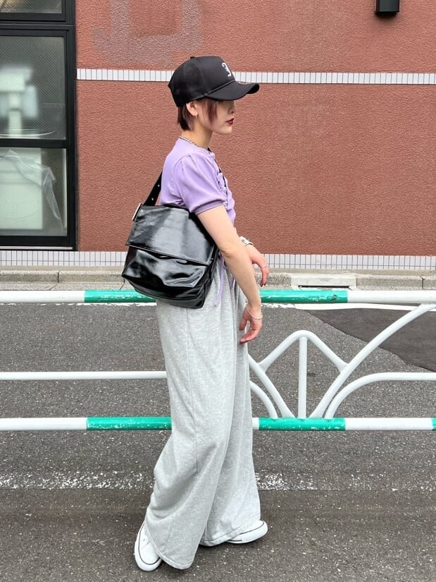 ブラック系のハンドバッグ、パープル系のTシャツ/カットソー、グレー系のその他パンツを着用したレディースの夏コーディネートの2枚目の写真