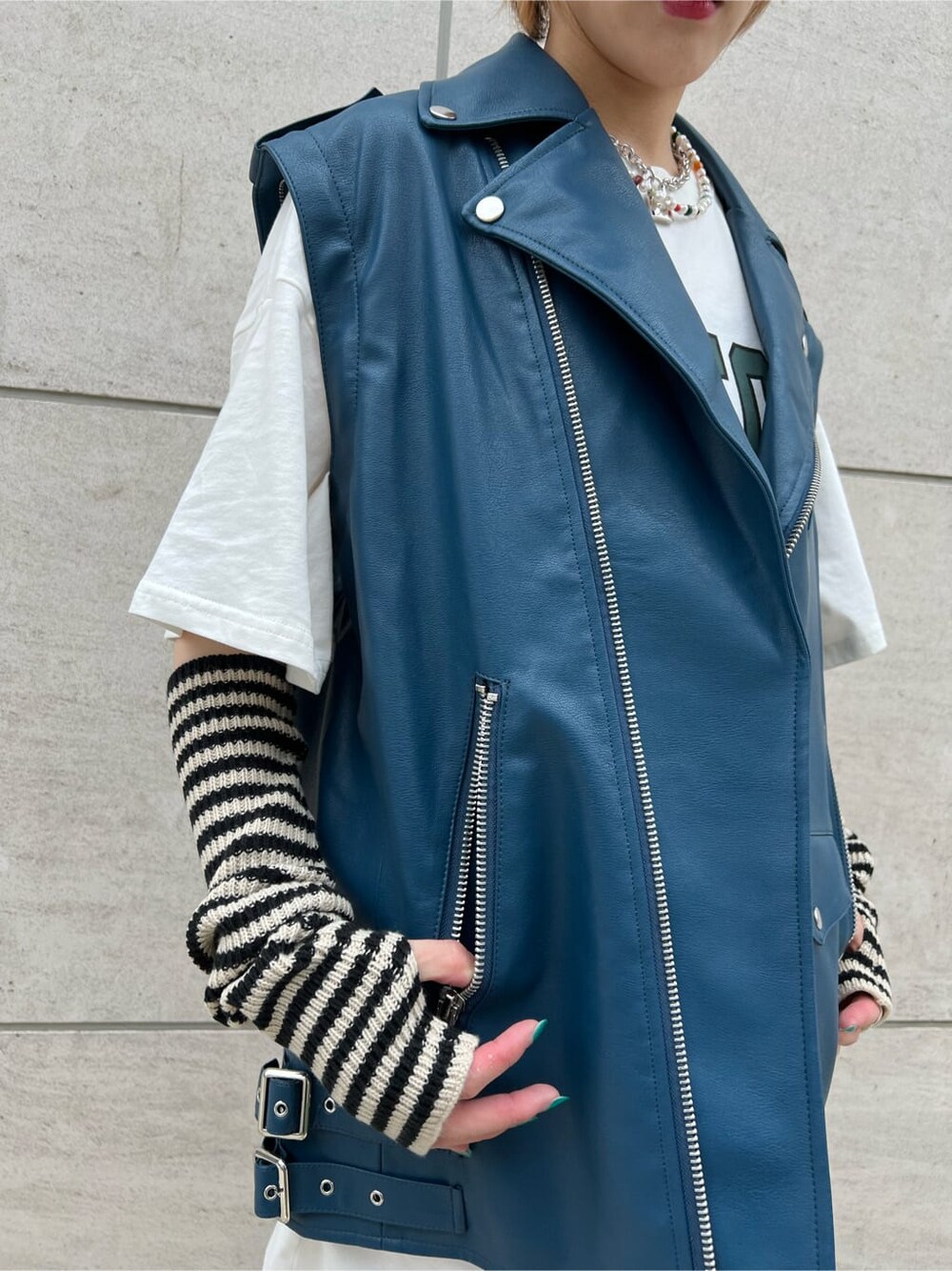 ブラック系のデニムパンツ、ホワイト系のTシャツ/カットソー、ブラック系のブーツを着用したレディースの秋コーディネートの7枚目の写真