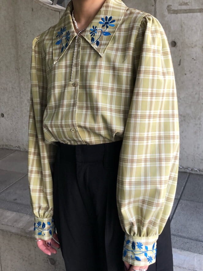 ブラック系のトレンチコート、グリーン系のシャツ/ブラウス、ブラック系のスラックスを着用したレディースの春コーディネートの6枚目の写真
