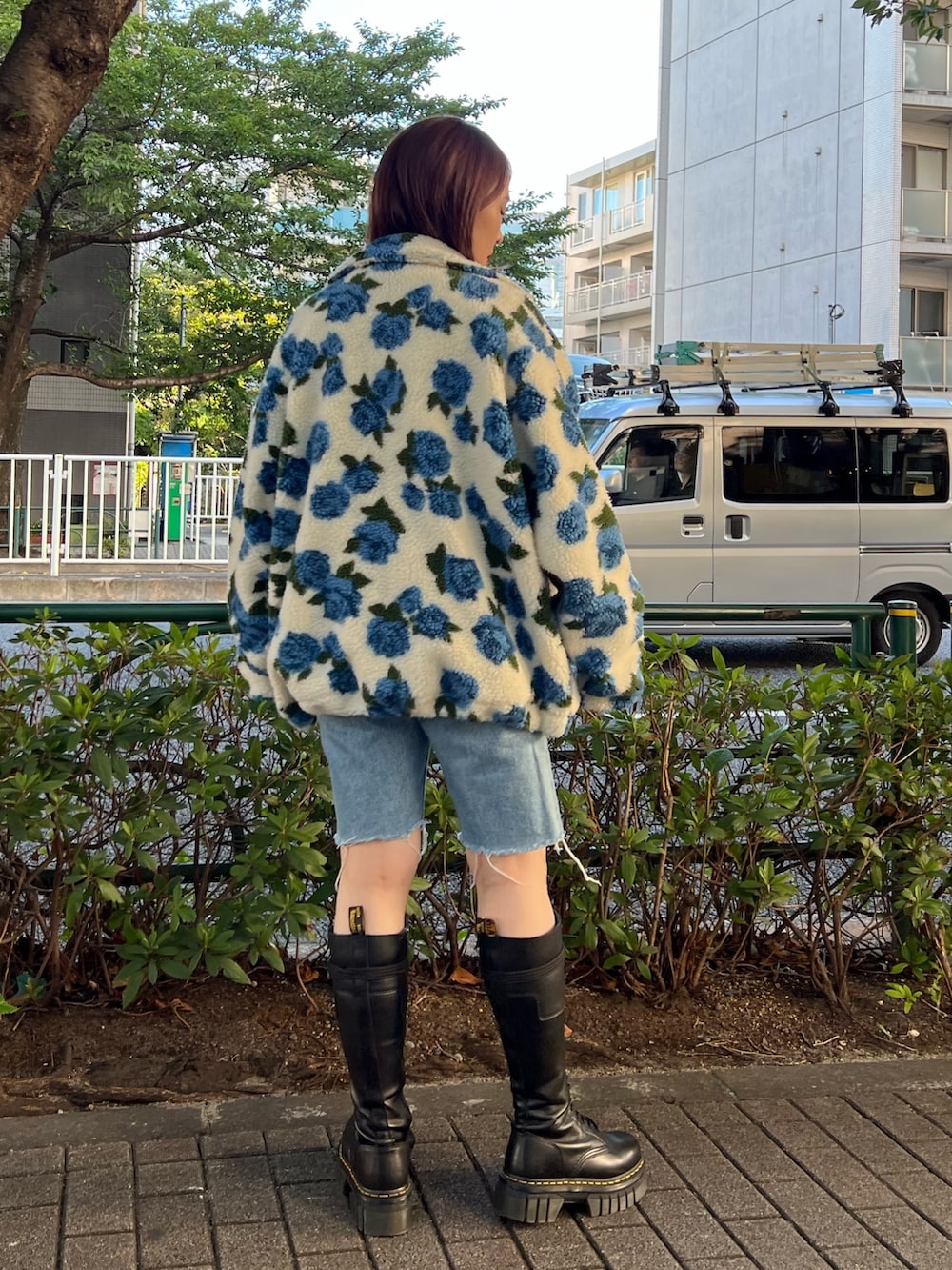 ホワイト系のブルゾン、ブラック系のTシャツ/カットソー、ブラック系のブーツを着用したレディースの秋コーディネートの3枚目の写真