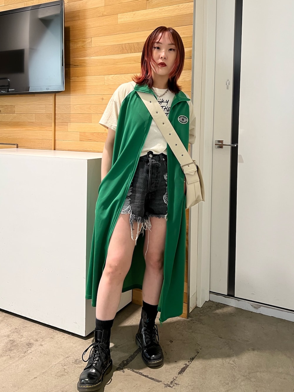 ホワイト系のタンクトップ、グリーン系のワンピース、ホワイト系のメッセンジャーバッグを着用したレディースの春コーディネートの2枚目の写真