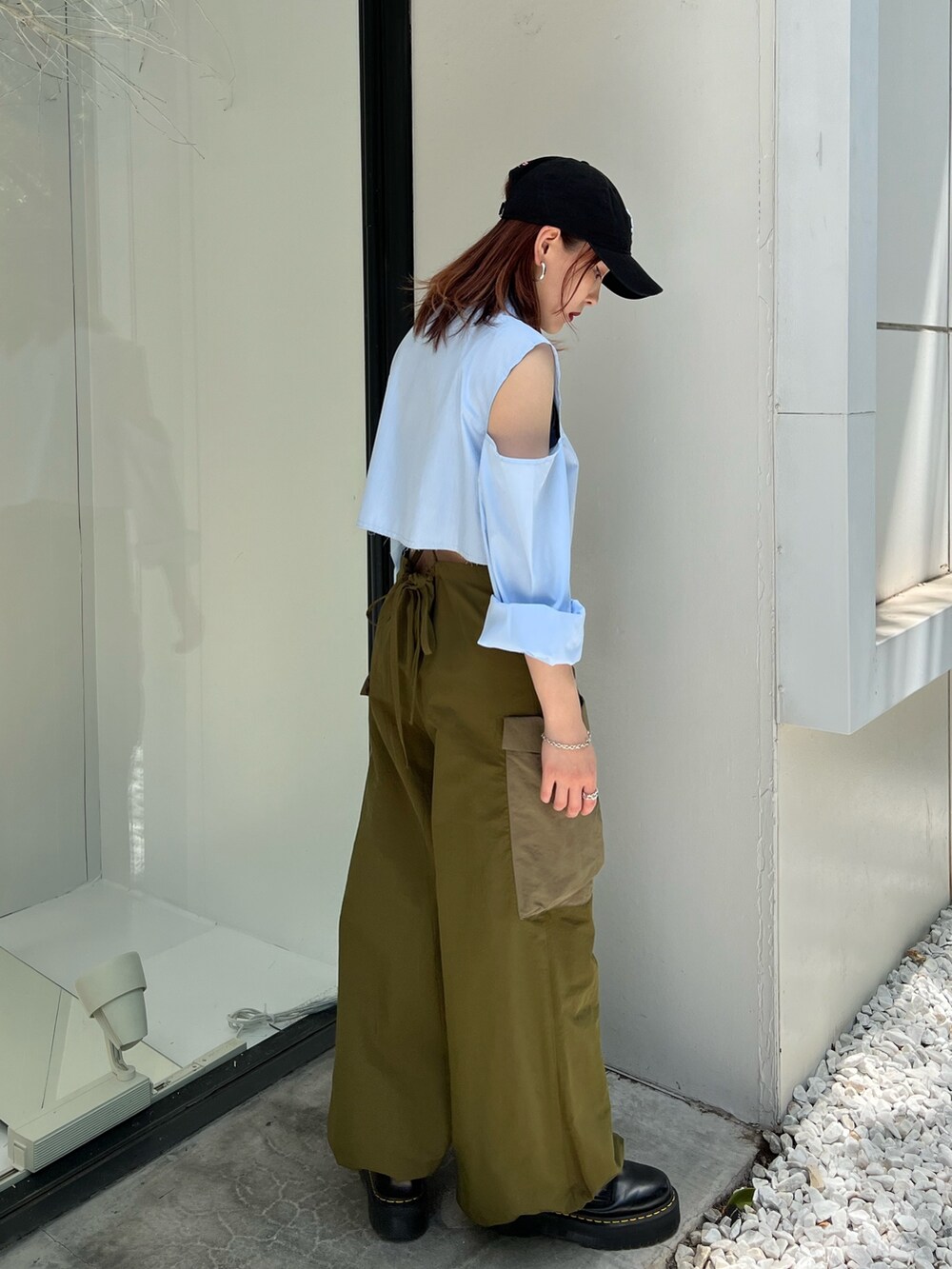 グリーン系のサロペット/オーバーオール、ブルー系のシャツ/ブラウス、ブラック系のキャップを着用したレディースの夏コーディネートの2枚目の写真