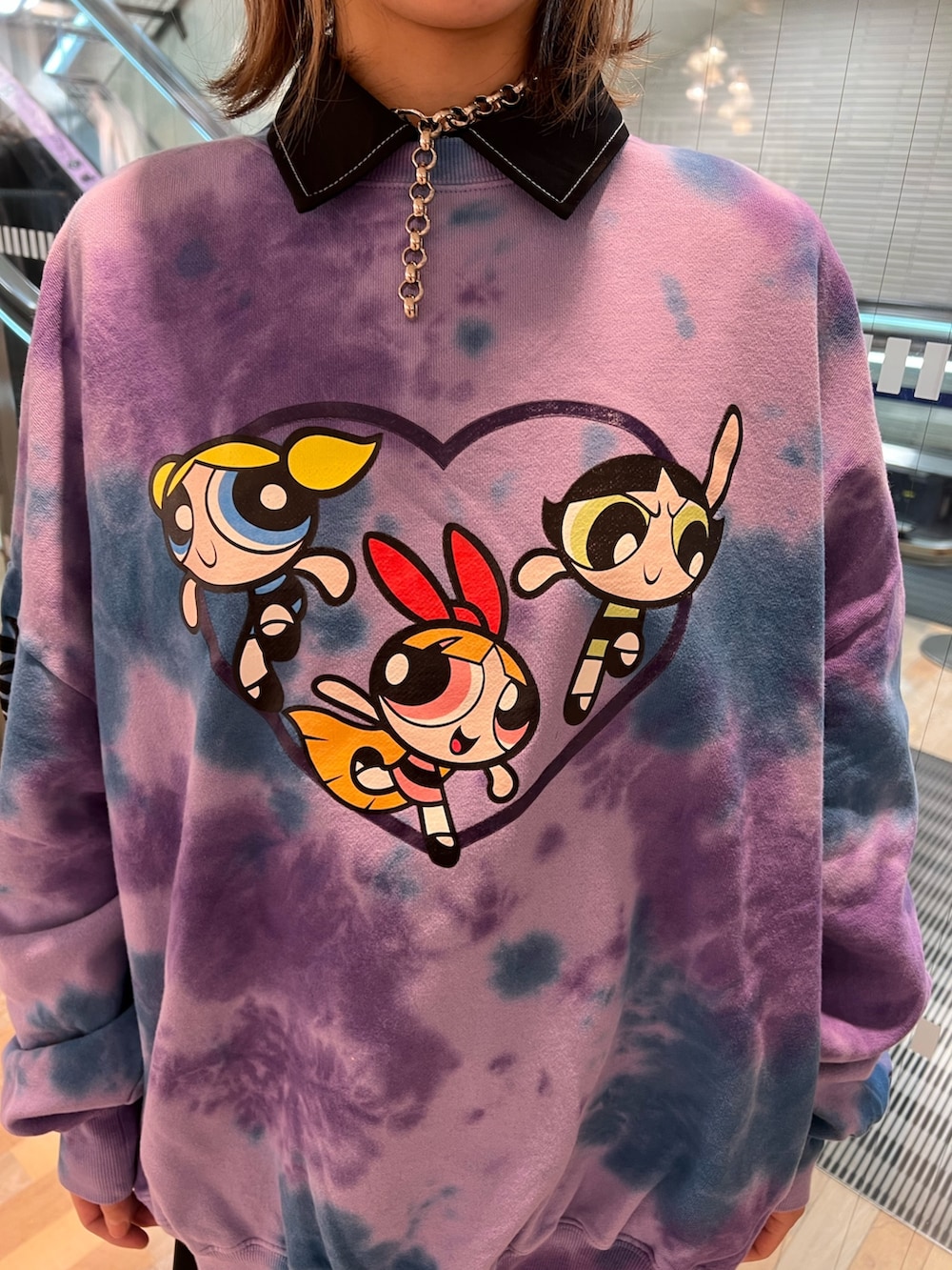 パープル系のスウェット、ブラック系のワンピース、ブラック系のローファーを着用したレディースの春コーディネートの6枚目の写真