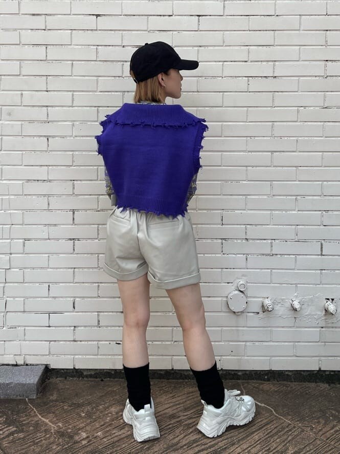 ホワイト系のスニーカー、パープル系のベスト、パープル系のその他トップスを着用したレディースの秋コーディネートの3枚目の写真