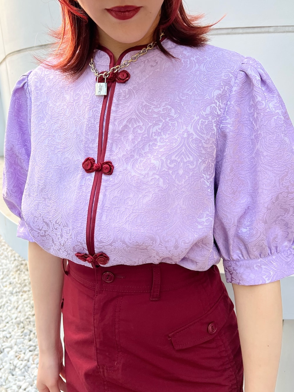 パープル系のシャツ/ブラウス、レッド系のスカート、ブラック系のキャップを着用したレディースの春コーディネートの7枚目の写真