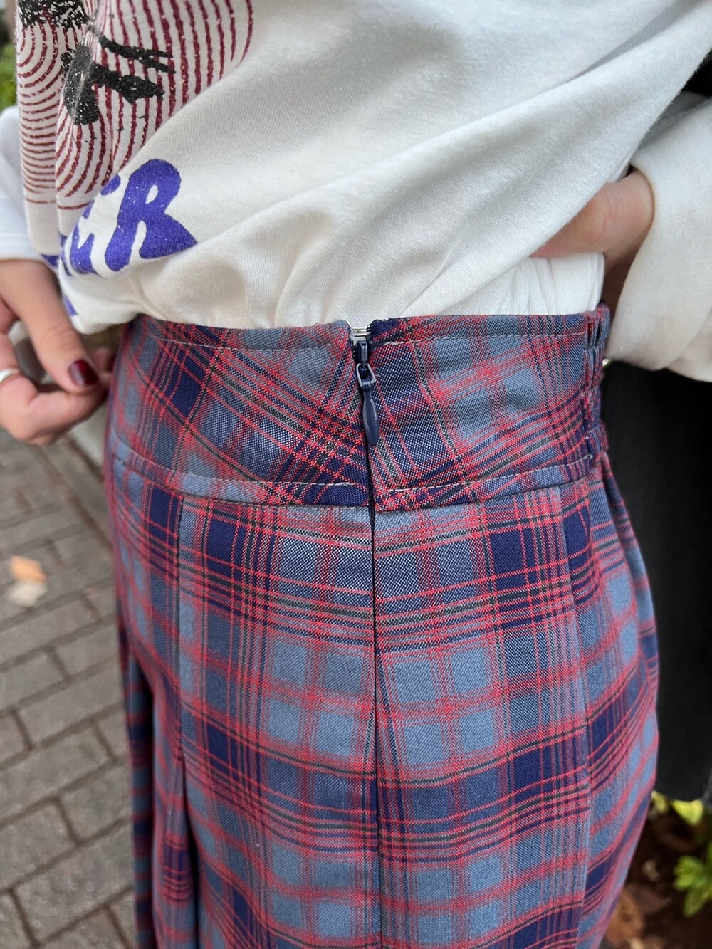 ブルー系のスカート、ホワイト系のTシャツ/カットソー、グレー系のベストを着用したレディースの春コーディネートの9枚目の写真