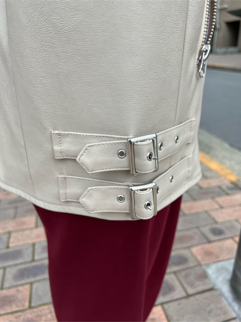 ブラック系のキャミソール、ホワイト系のスニーカー、ホワイト系のライダースジャケットを着用したレディースの秋コーディネートの10枚目の写真