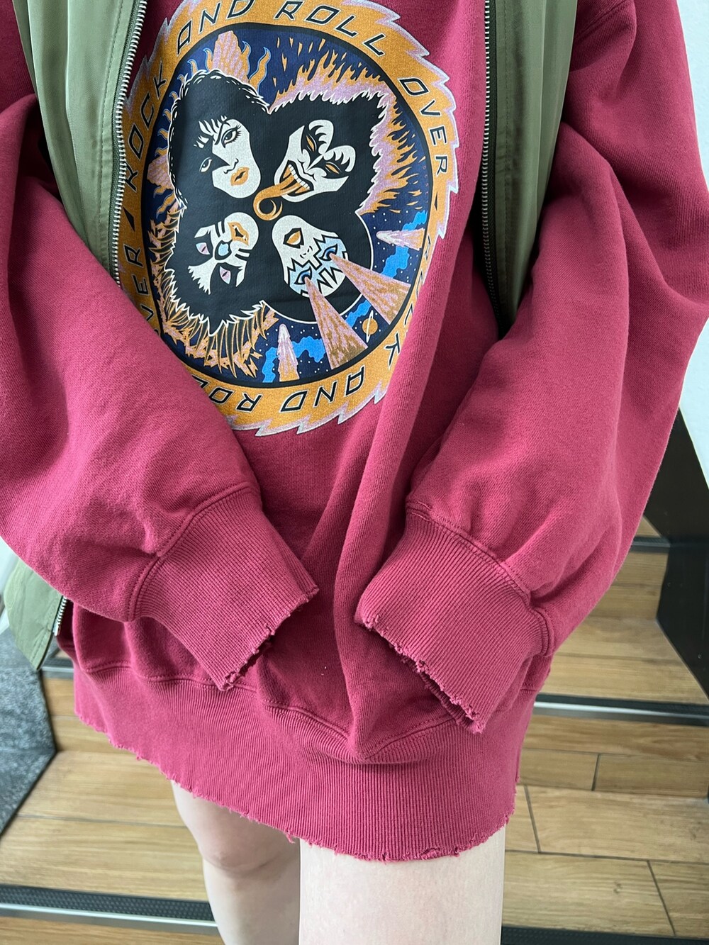 レッド系のスウェット、グリーン系のMA-1、ブラック系のデニムパンツを着用したレディースの冬コーディネートの6枚目の写真