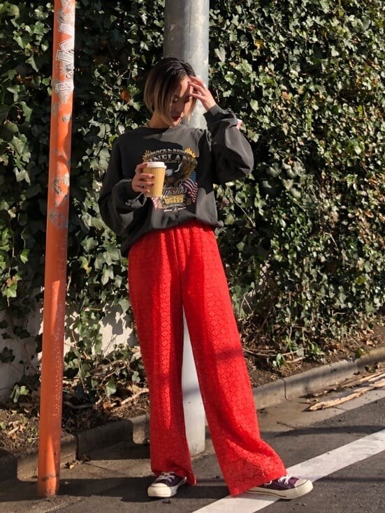 オレンジ系のスラックス、ブラック系のTシャツ/カットソーを着用したレディースの春コーディネートの2枚目の写真