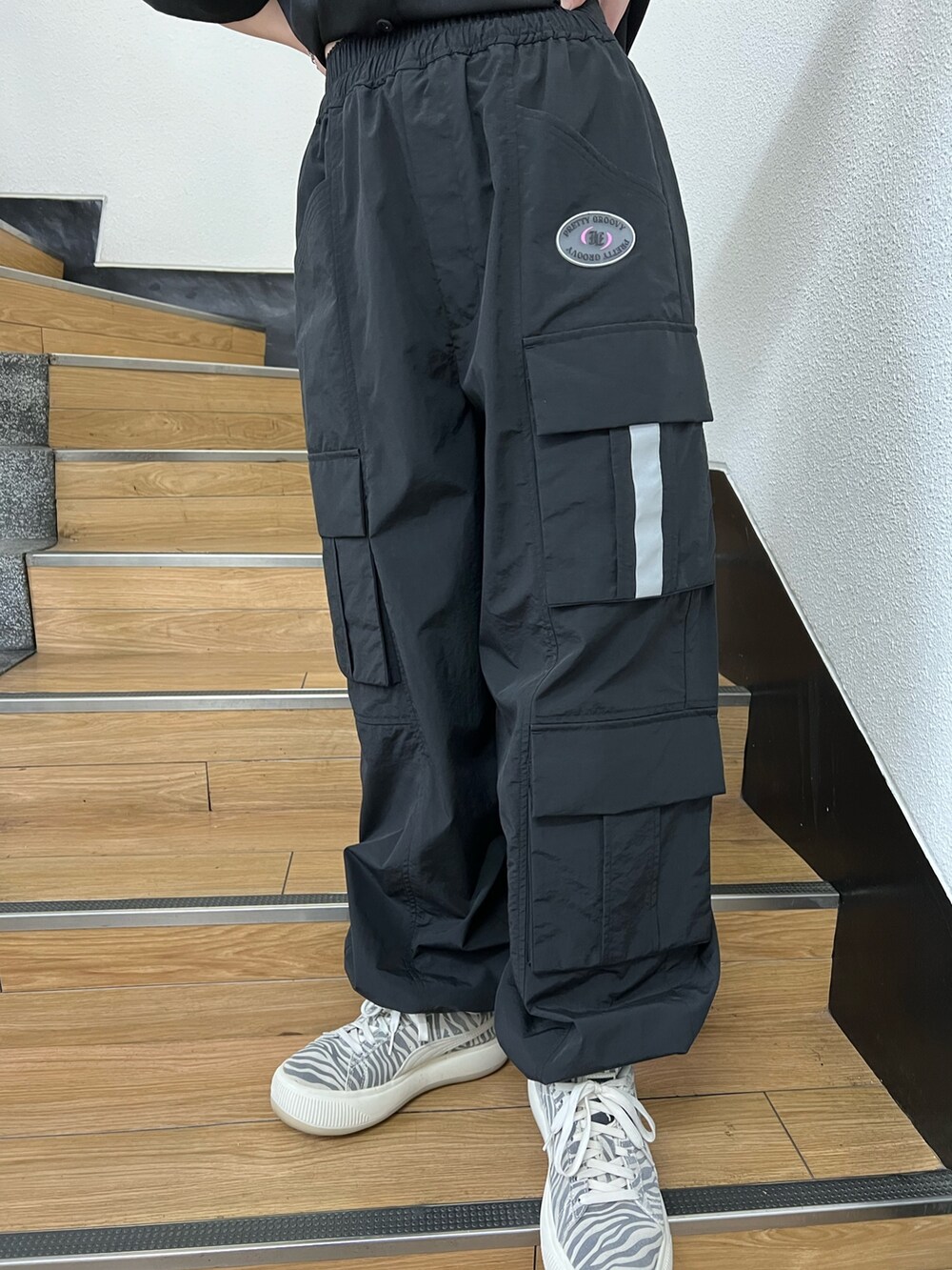 ブラック系のカーゴパンツ、ブラック系のシャツ/ブラウス、ホワイト系のハットを着用したレディースの春コーディネートの8枚目の写真