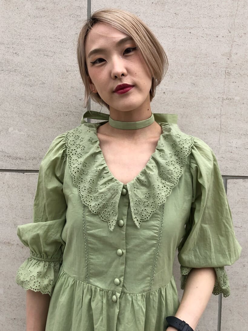 ブラック系のハンドバッグ、グリーン系のワンピース、シルバー系のチョーカーを着用したレディースの夏コーディネートの5枚目の写真