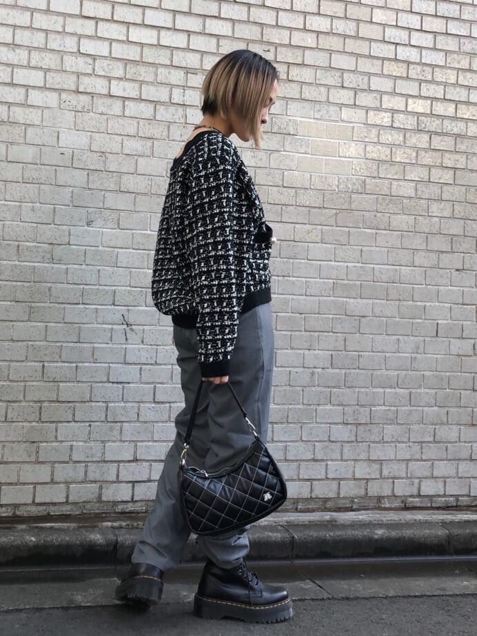 グレー系のスラックス、ブラック系のハンドバッグ、ブラック系のカーディガン/ボレロを着用したレディースの冬コーディネートの2枚目の写真