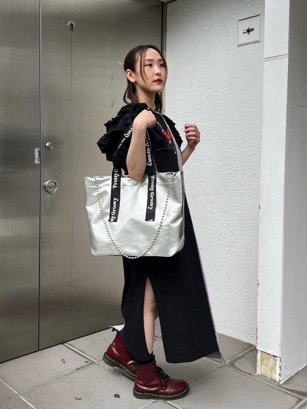 シルバー系のトートバッグ、ブラック系のシャツ/ブラウス、ブラック系のワンピースを着用したレディースの春コーディネートの4枚目の写真