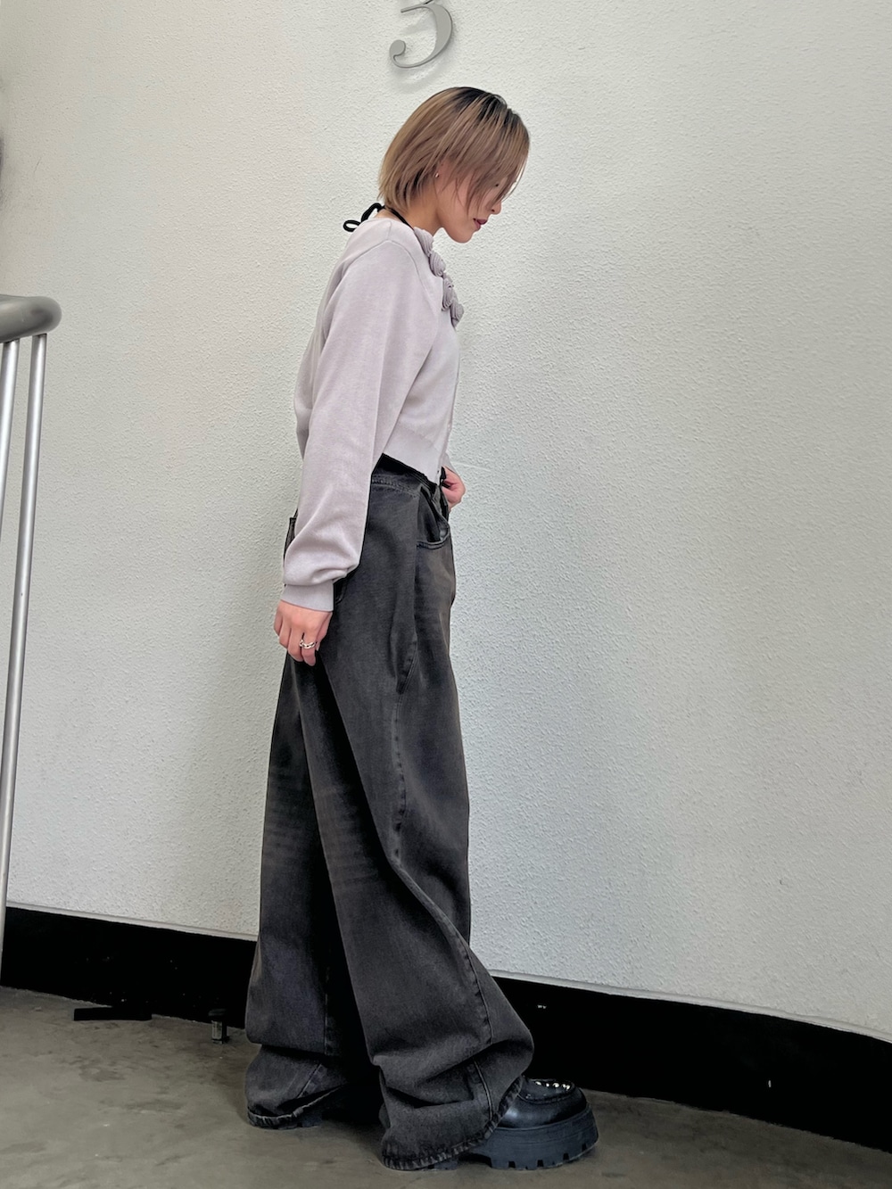 グレー系のニット/セーター、ブラック系のキャミソール、ブラック系のデニムパンツを着用したレディースの春コーディネートの4枚目の写真