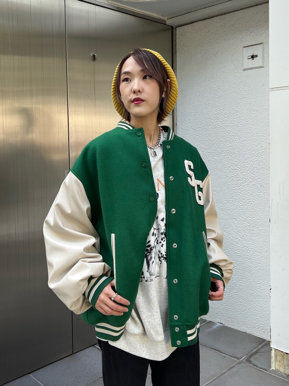 グレー系のスウェット、グリーン系のスタジャン、ホワイト系のスニーカーを着用したレディースの秋コーディネートの6枚目の写真