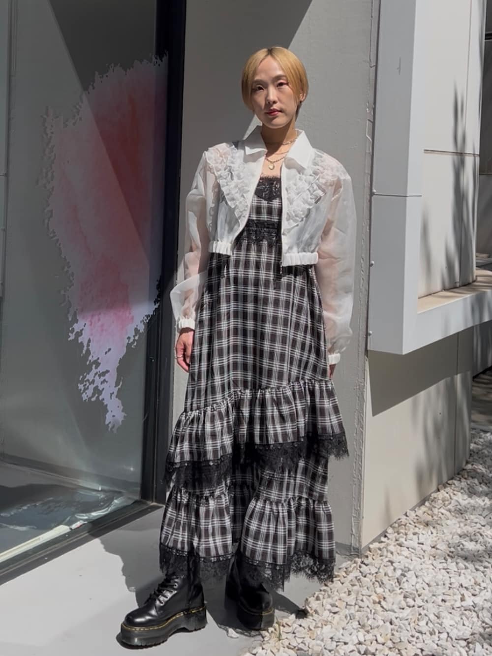 ブラック系のワンピース、ホワイト系のブルゾン、ブラック系のブーツを着用したレディースの夏コーディネートの10枚目の写真