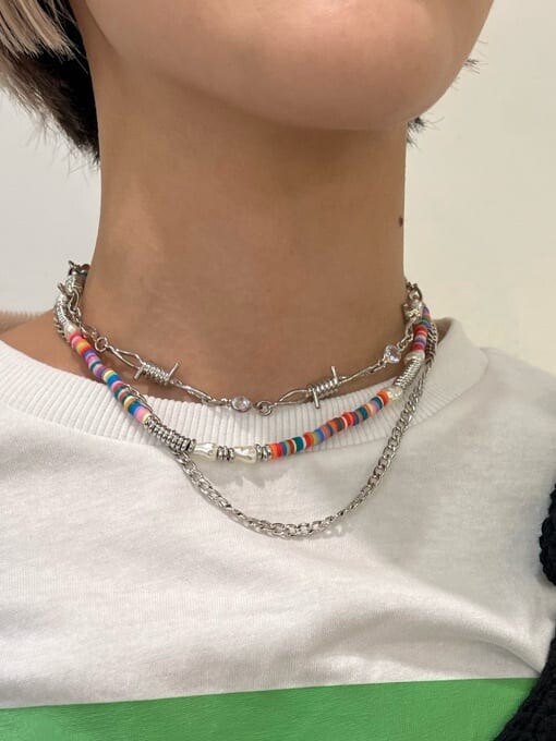 ブラック系のニット/セーター、パープル系のスラックス、ホワイト系のTシャツ/カットソーを着用したレディースの夏コーディネートの9枚目の写真