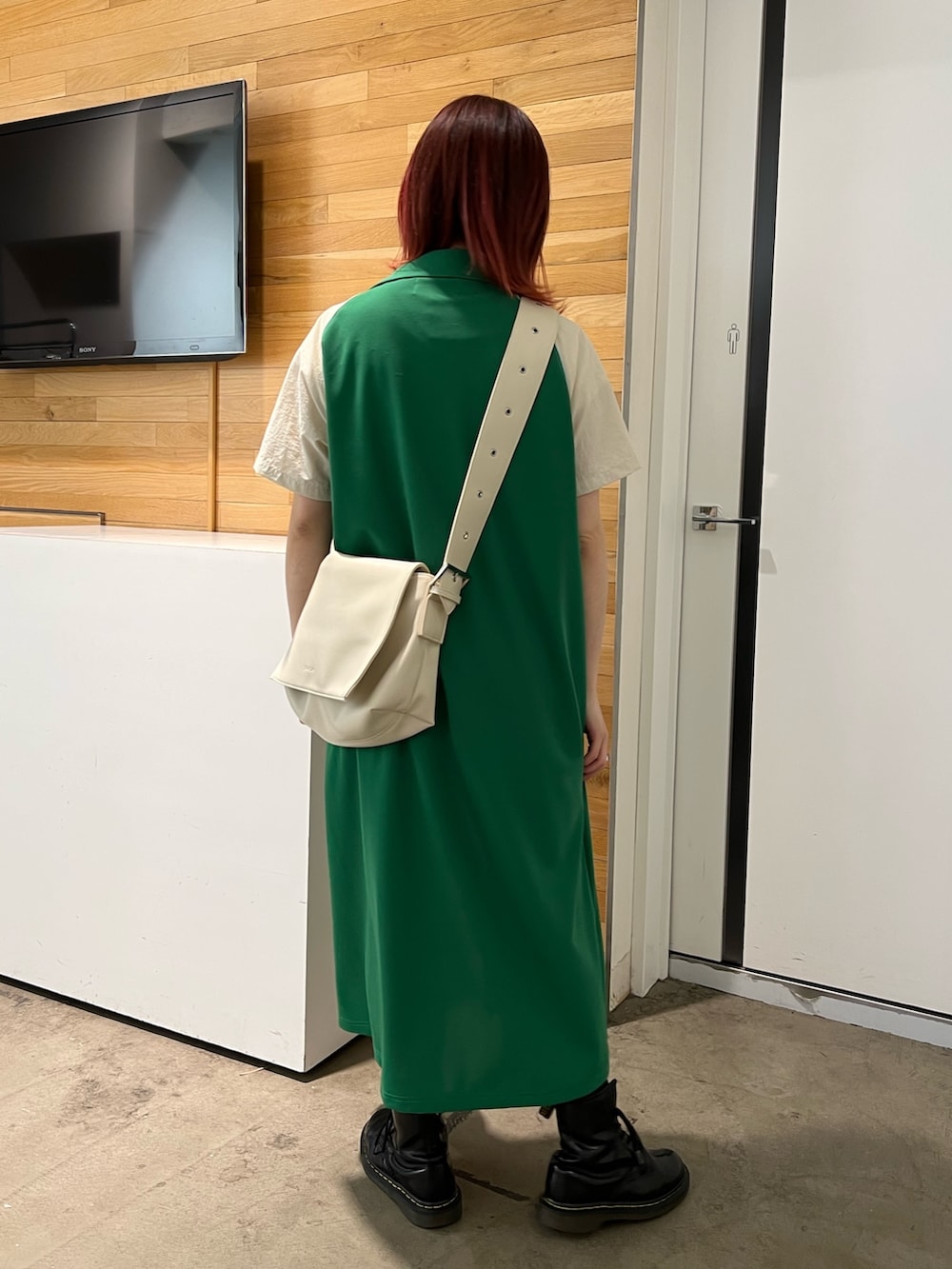 ホワイト系のタンクトップ、グリーン系のワンピース、ホワイト系のメッセンジャーバッグを着用したレディースの春コーディネートの5枚目の写真