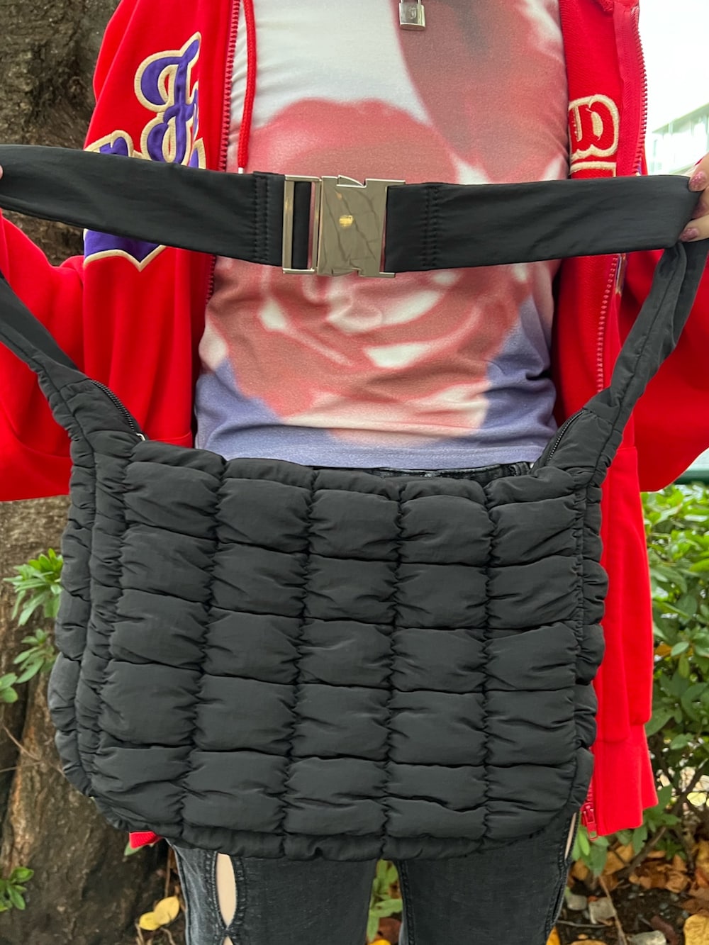 レッド系のパーカー、パープル系のTシャツ/カットソー、ブラック系のデニムパンツを着用したレディースの春コーディネートの9枚目の写真