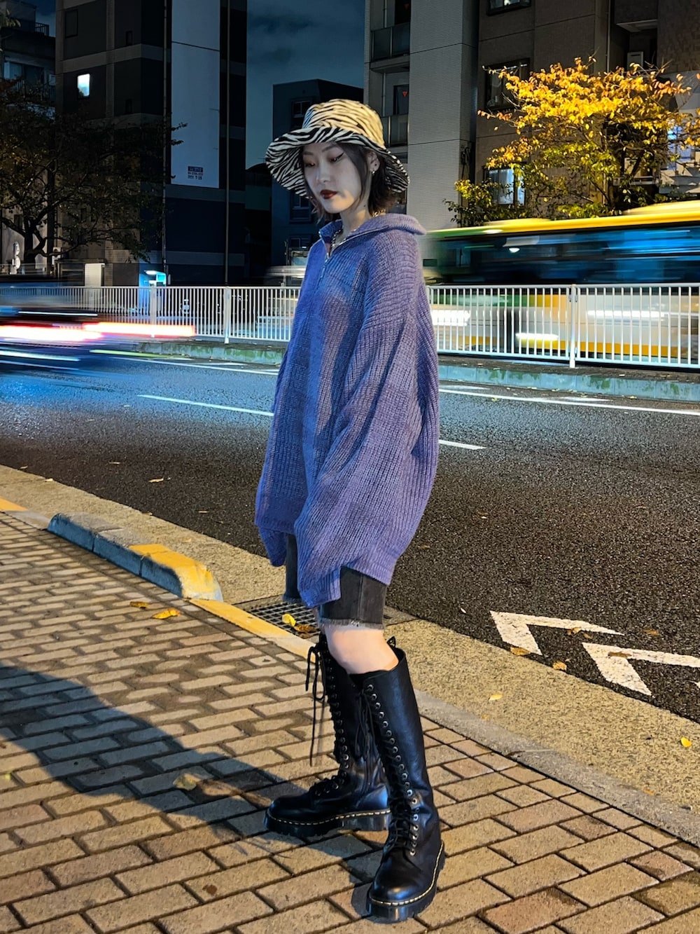 パープル系のニット/セーター、ブラック系のデニムパンツ、ホワイト系のハットを着用したレディースの冬コーディネートの2枚目の写真