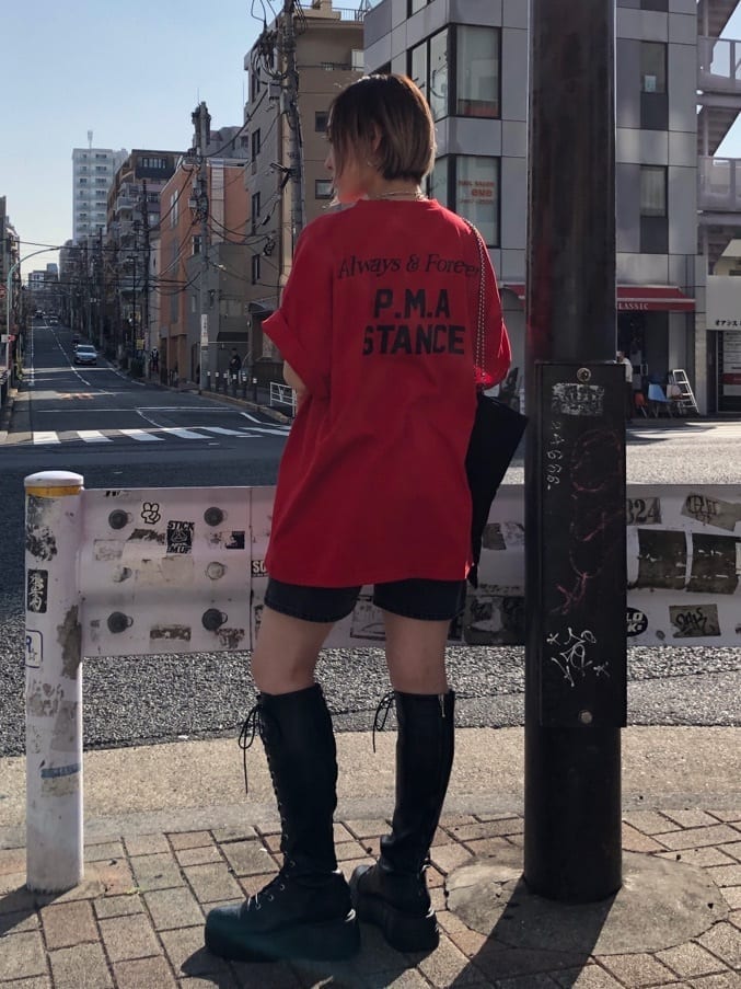 ブラック系のブーツ、ブラック系のトートバッグ、ブラック系のデニムパンツを着用したレディースの春コーディネートの3枚目の写真