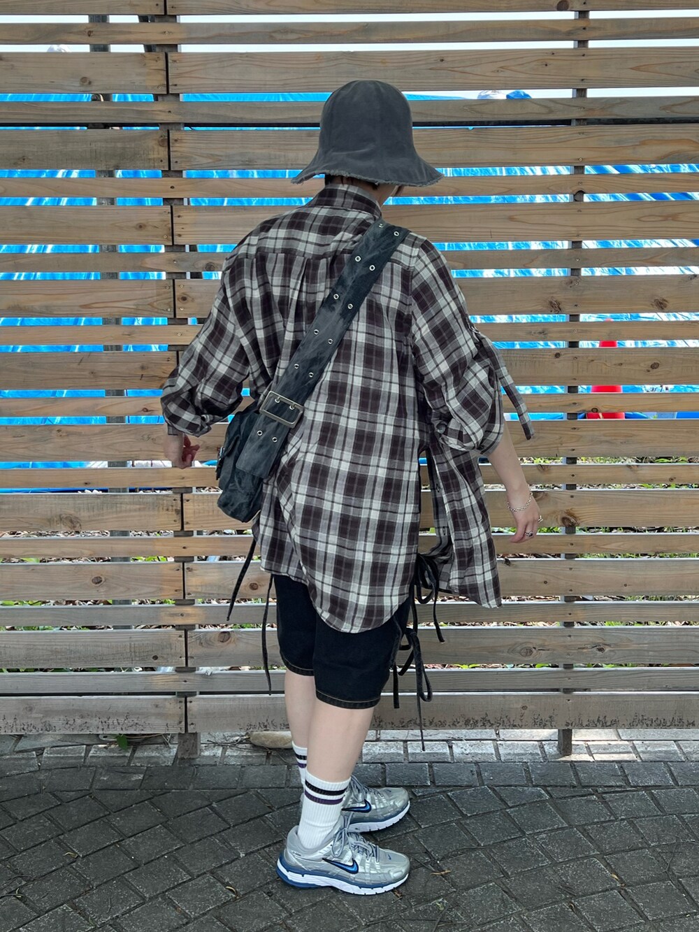 ブラウン系のシャツ/ブラウス、ブラック系のデニムパンツ、ブラック系のメッセンジャーバッグを着用したレディースの春コーディネートの3枚目の写真