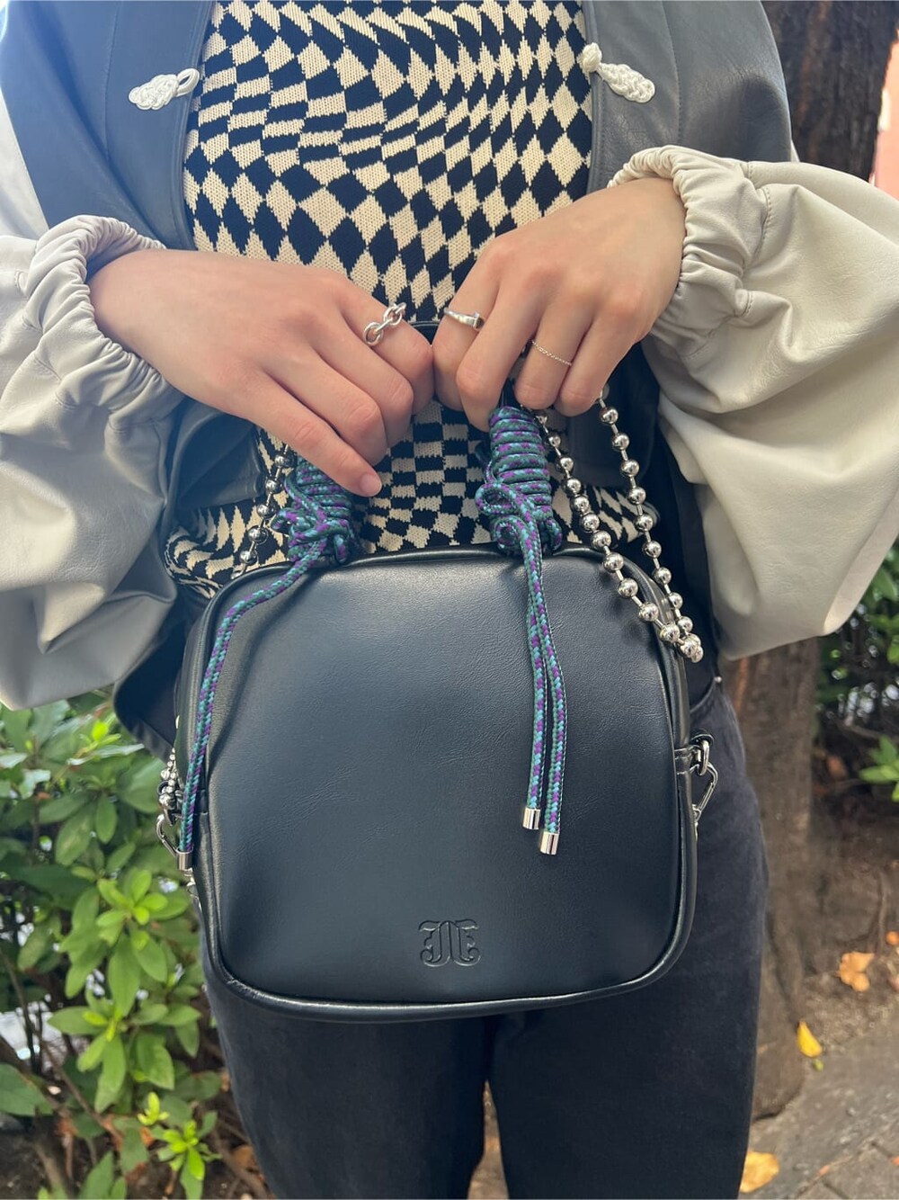 ブラック系のニット/セーター、ホワイト系のスニーカー、ブラック系のデニムパンツを着用したレディースの秋コーディネートの9枚目の写真