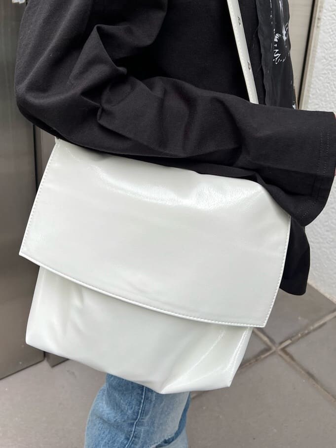 ブルー系のデニムパンツ、ホワイト系のハンドバッグ、パープル系のTシャツ/カットソーを着用したレディースの夏コーディネートの10枚目の写真