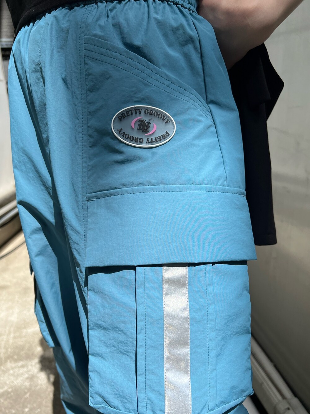 ブラック系のTシャツ/カットソー、ブラック系のテーラードジャケット、ブルー系のカーゴパンツを着用したレディースの夏コーディネートの10枚目の写真