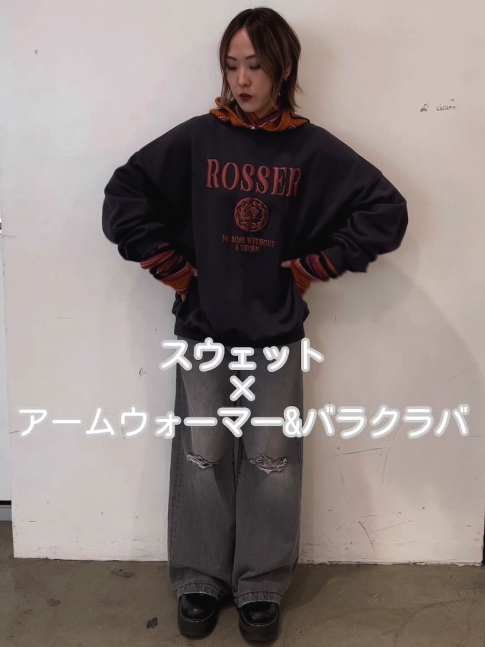 ブラック系のスウェット、ブラック系のデニムパンツ、ピンク系のアームカバーを着用したレディースの秋コーディネートの6枚目の写真