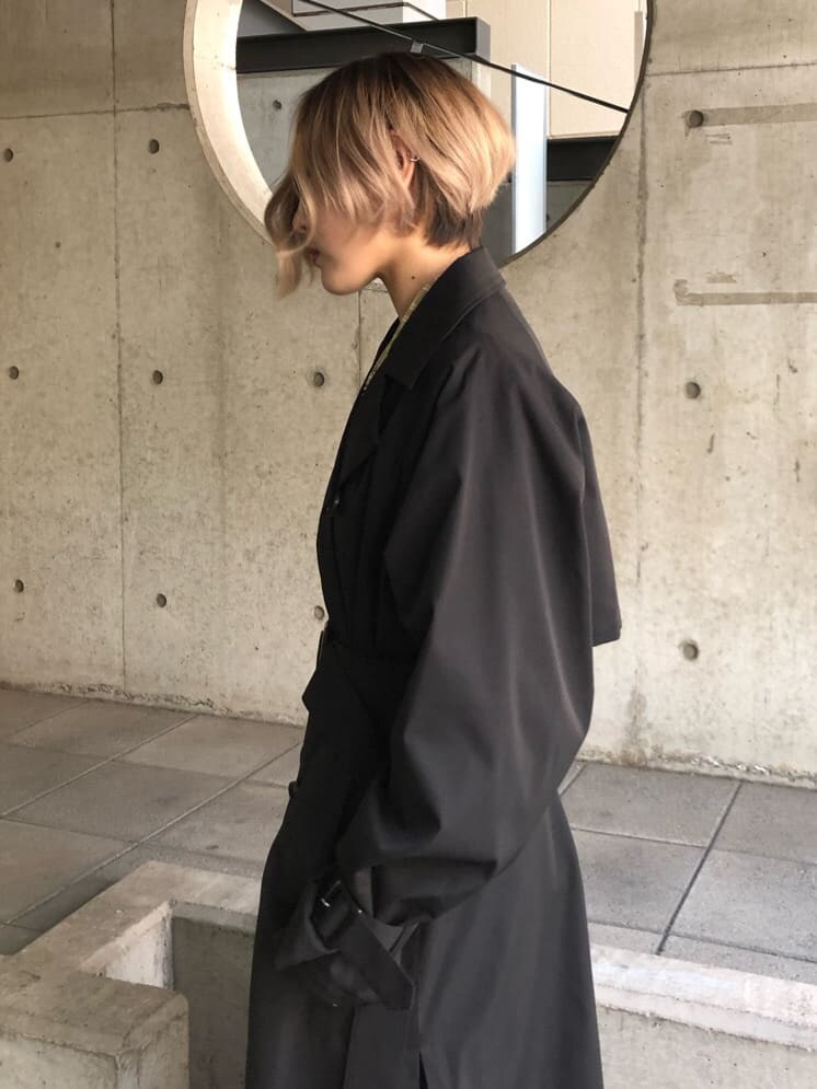 ブラック系のトレンチコート、グリーン系のシャツ/ブラウス、ブラック系のスラックスを着用したレディースの春コーディネートの3枚目の写真