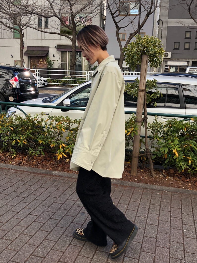 グリーン系のシャツ/ブラウス、ブラック系のスラックスを着用したレディースの春コーディネートの2枚目の写真