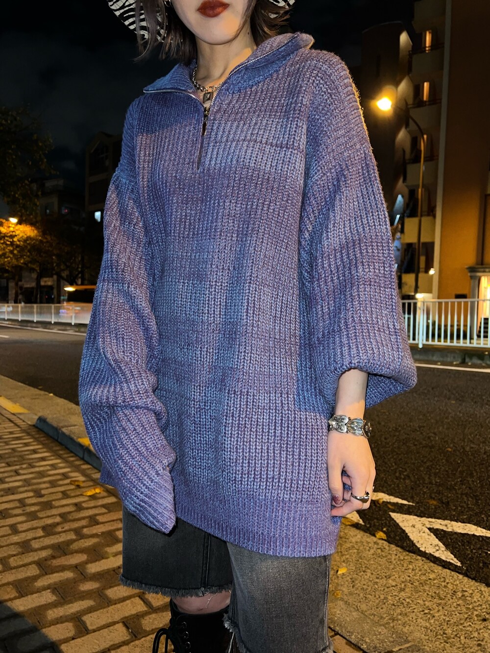 パープル系のニット/セーター、ブラック系のデニムパンツ、ホワイト系のハットを着用したレディースの冬コーディネートの7枚目の写真