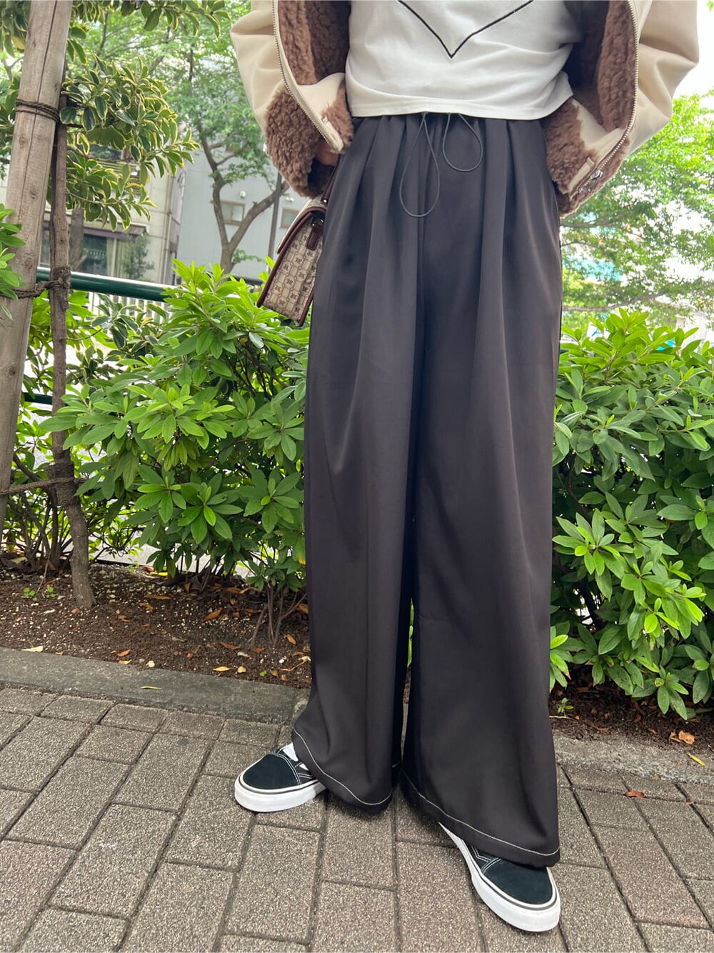 ブラウン系のハンドバッグ、ホワイト系のTシャツ/カットソー、ブラック系のその他パンツを着用したレディースの秋コーディネートの9枚目の写真