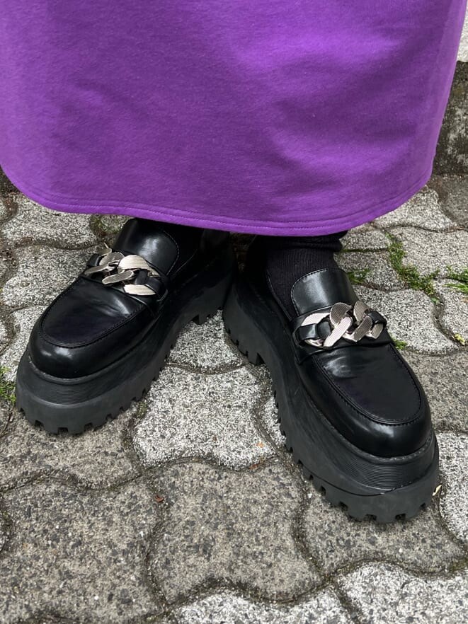 パープル系のワンピース、ブラック系のローファー、ブラック系のキャップを着用したレディースの春コーディネートの8枚目の写真