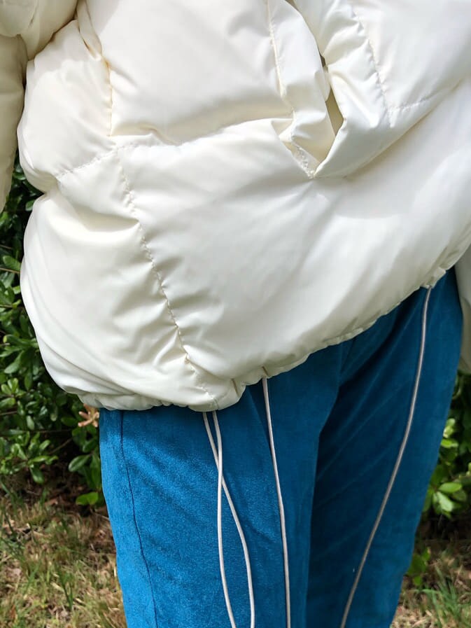 ホワイト系のシャツ/ブラウス、ホワイト系のダウンジャケット/コート、ブルー系のその他パンツを着用したレディースの春コーディネートの3枚目の写真