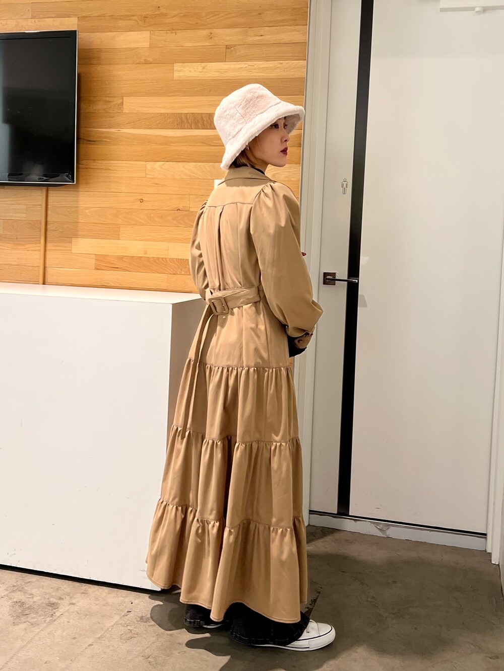 ブラック系のデニムパンツ、ブラック系のTシャツ/カットソー、ベージュ系のワンピースを着用したレディースの秋コーディネートの4枚目の写真